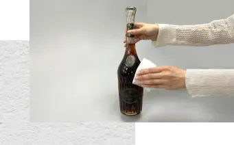 お酒のボトルを布で拭いている画像。